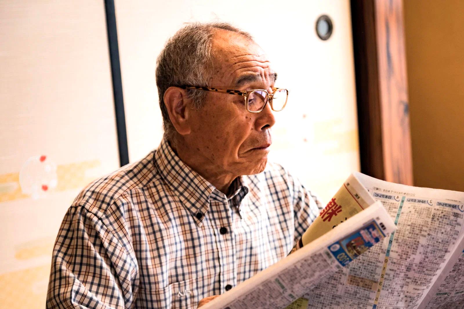自宅で椅子を使いながらヨガを行う高齢者