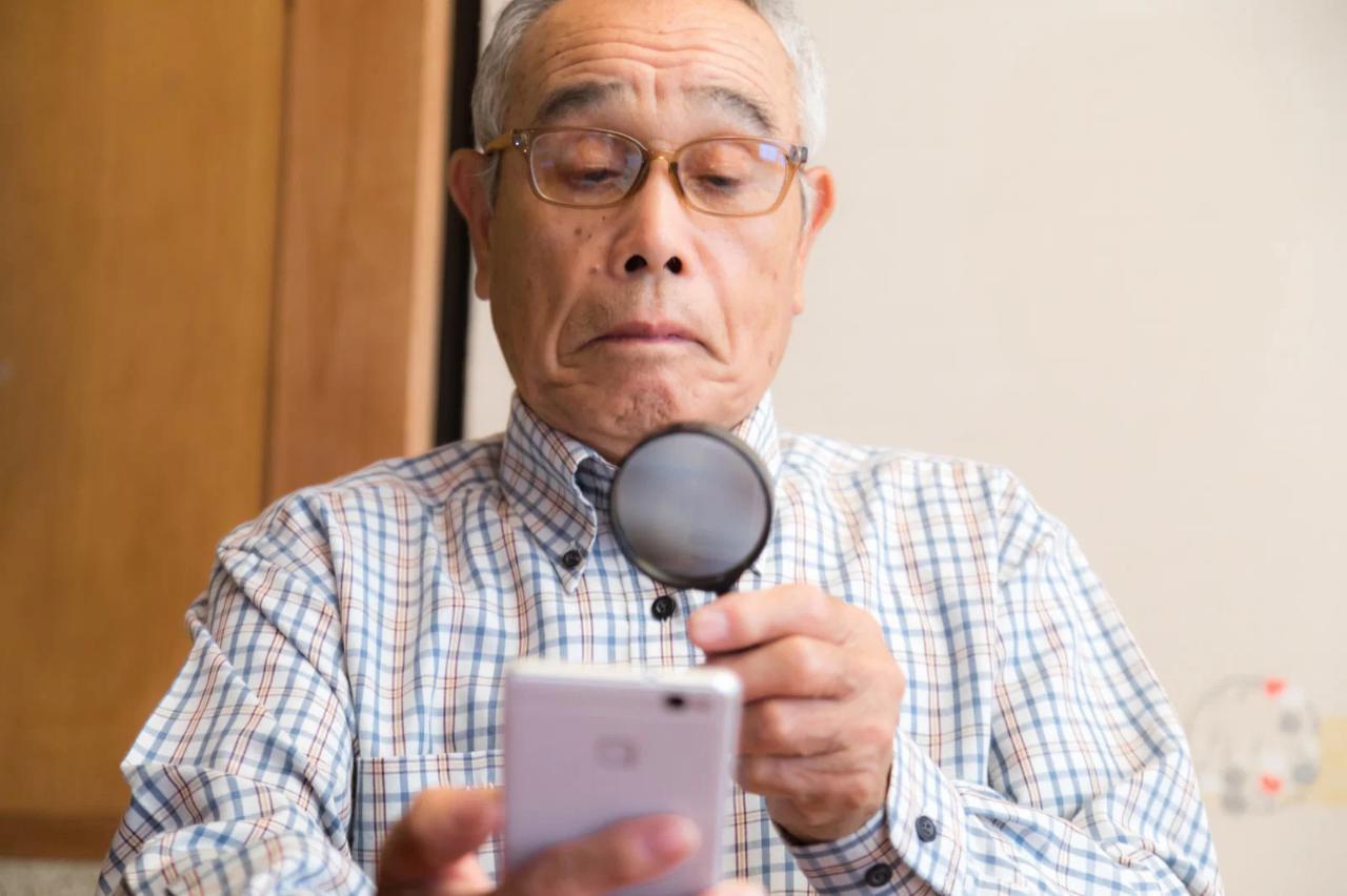 スマホ画面を拡大して読むシニア男性と、大きな文字で表示されたAIの回答