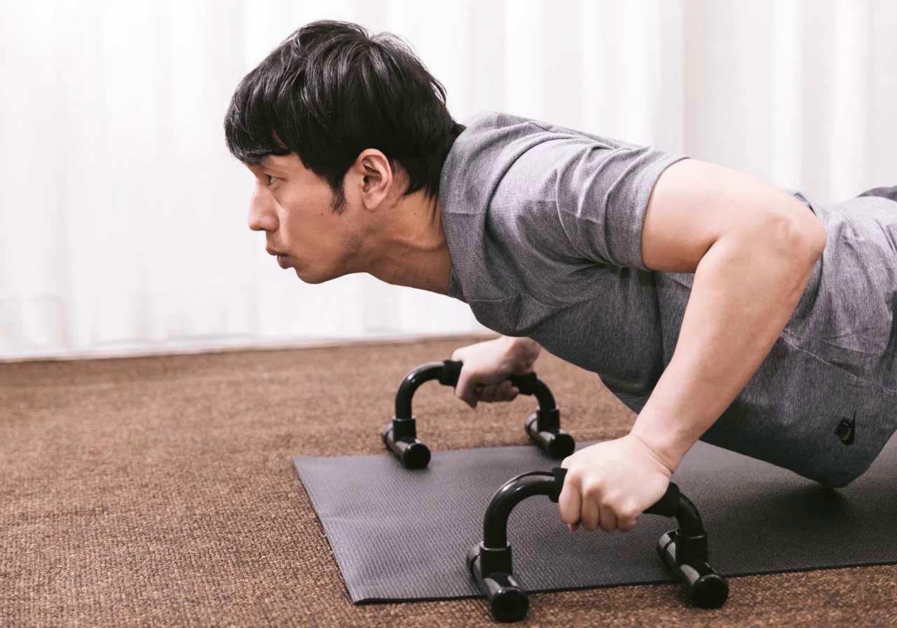 自宅で肩周りのセルフケアを行う男性のイメージ
