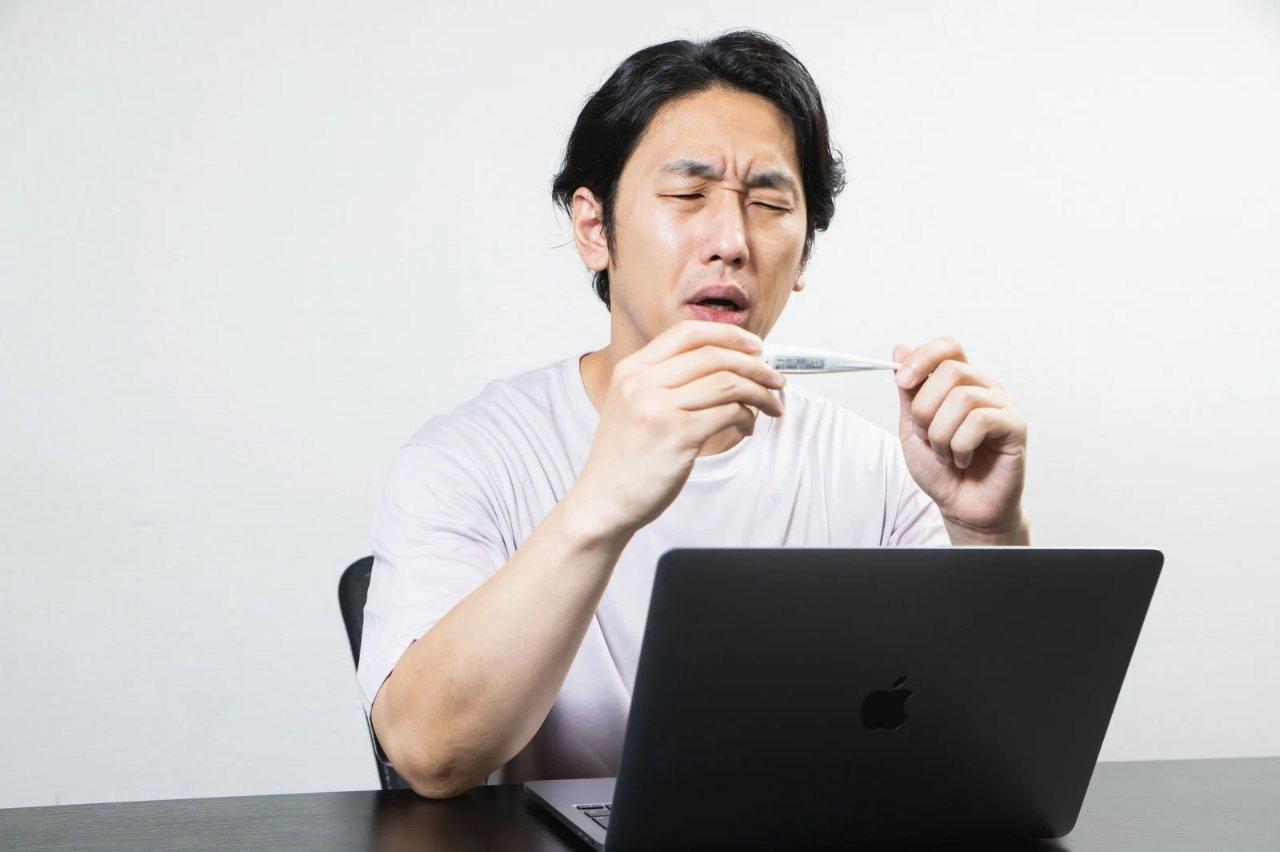 腰の痛みをこらえながら洗濯物を干す高齢者の表情