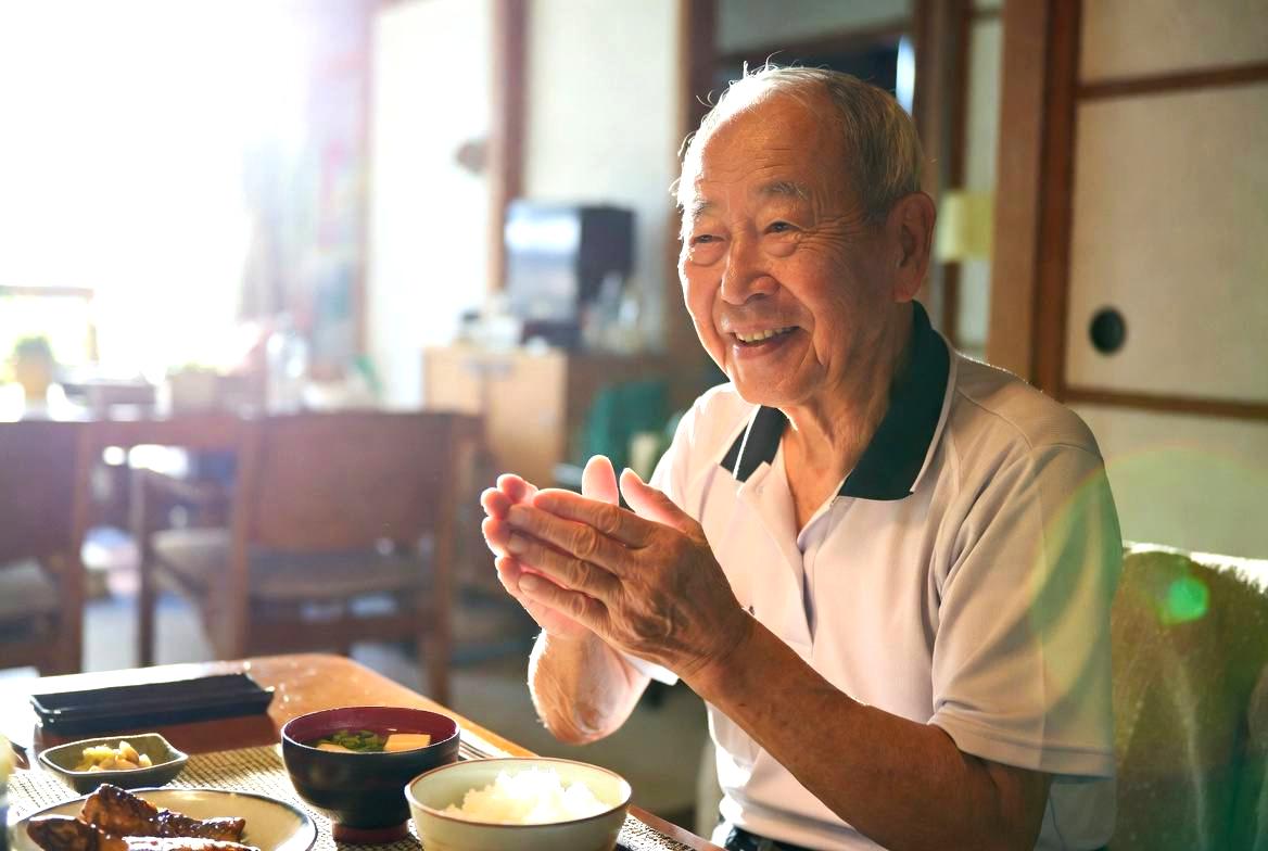 和食のテーブルで食事をする高齢者の手元