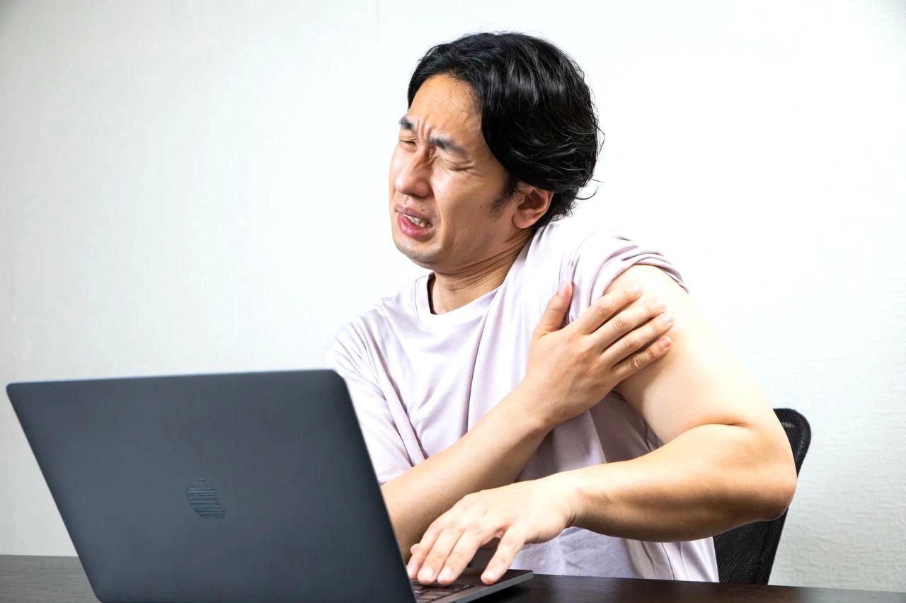ティッシュを持った40代男性が鼻の不調に悩む様子