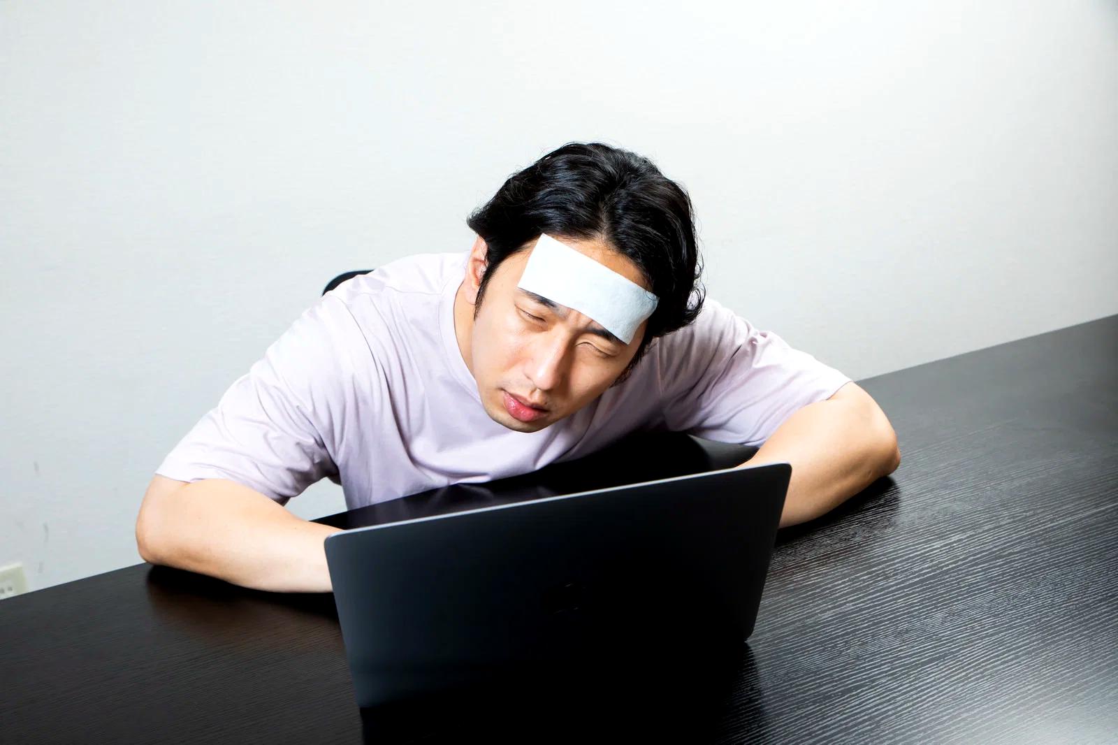 疲れや眠気を感じて椅子に座る高齢者