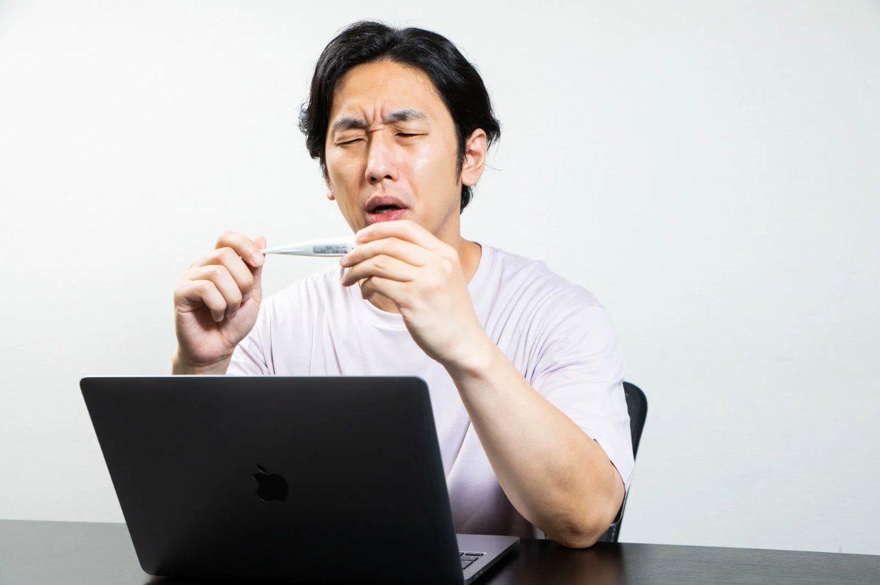 悪い姿勢でデスクワークをして腰に負担がかかる男性