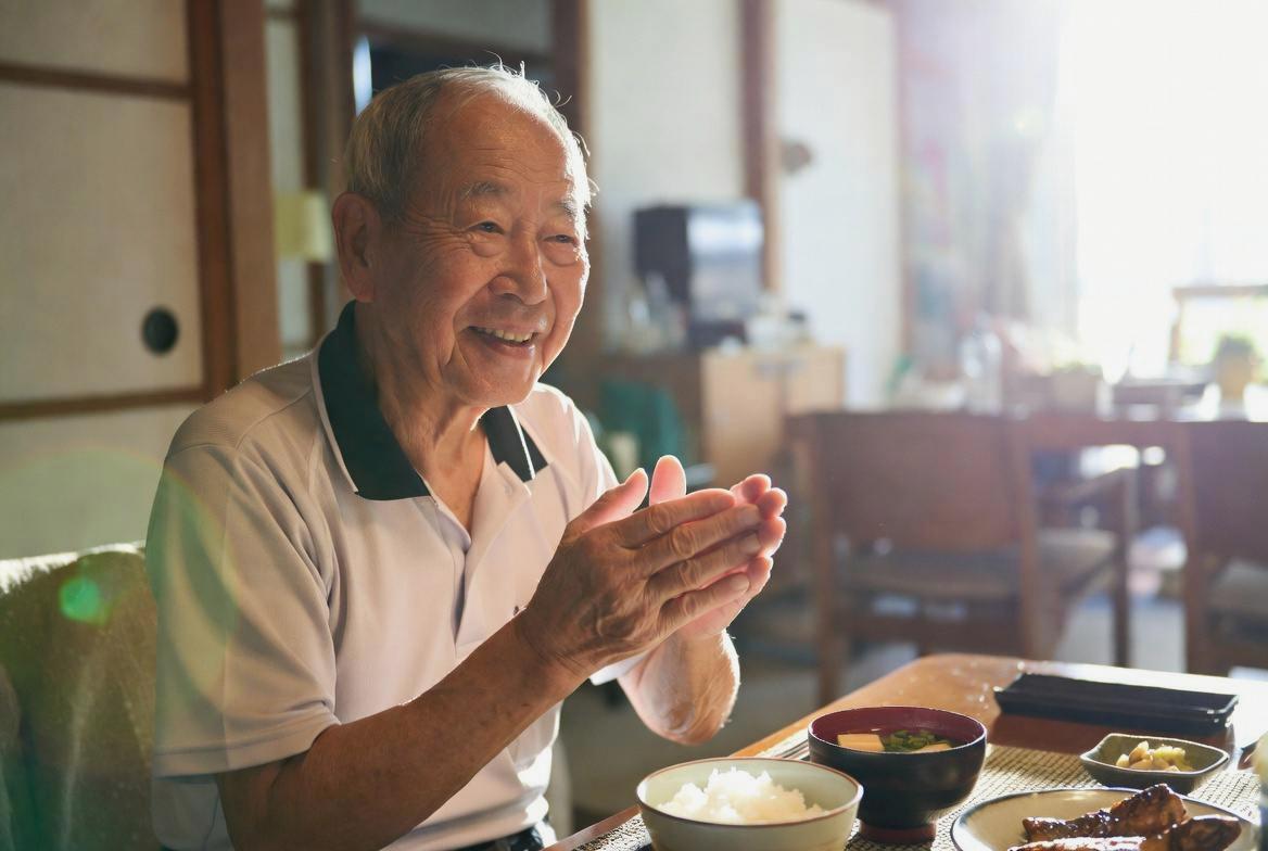 朝食について考えるシニア男性と健康食品