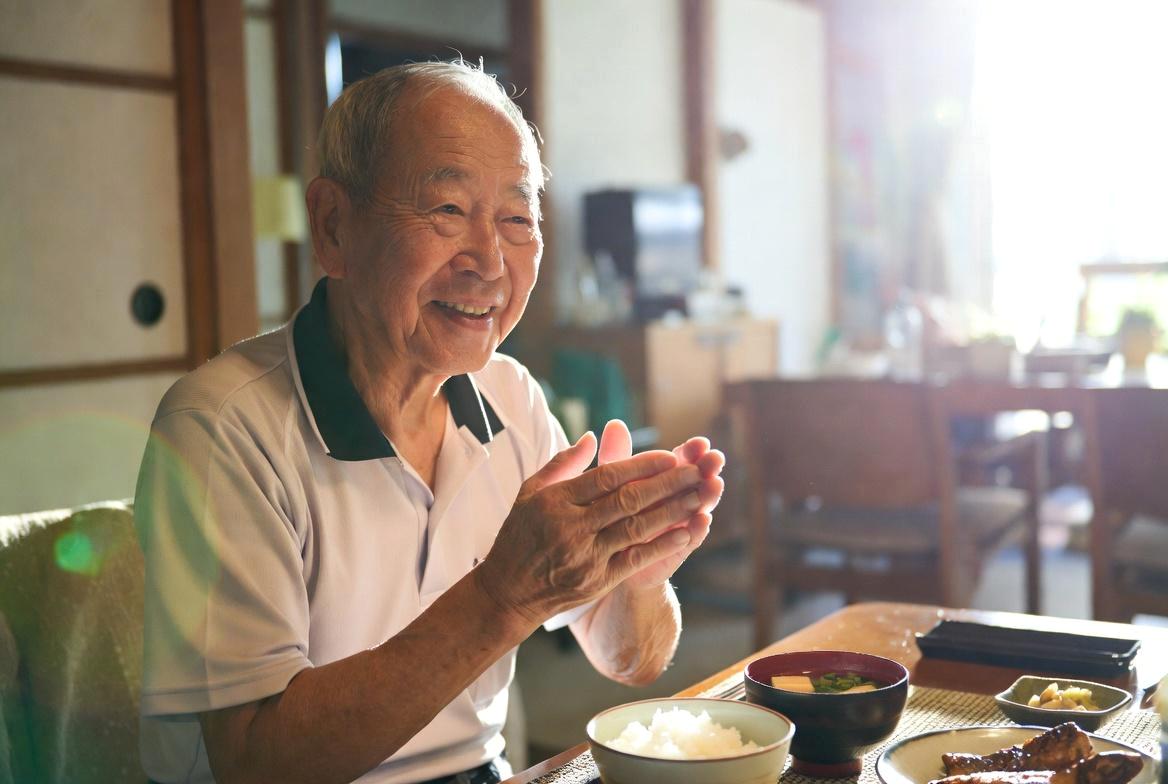 調味料が並ぶキッチンで食生活を見直す高齢者のイメージ