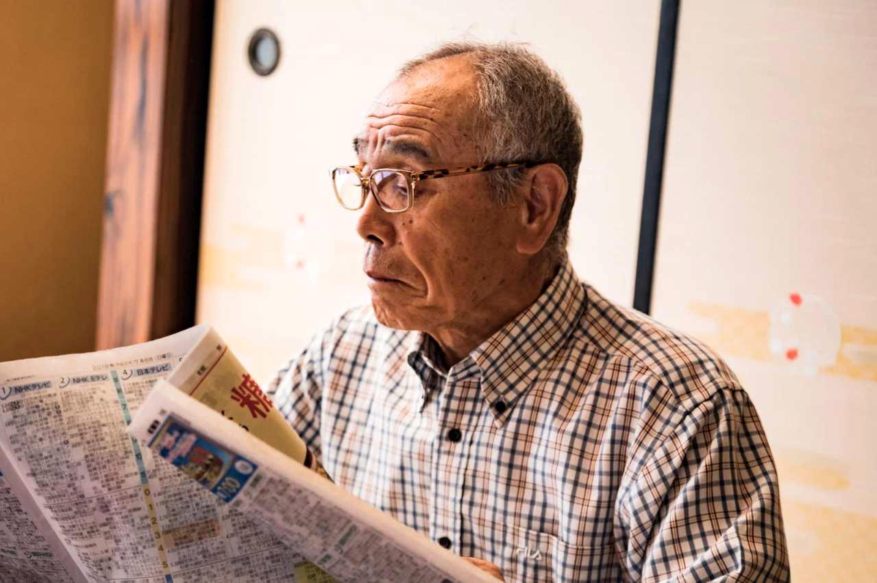 鏡を見て歯を確認する中高年男性