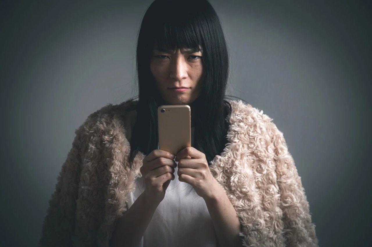 スマホのセキュリティ設定画面を真剣に見つめる高齢者の後ろ姿。鍵マークが強調表示されている