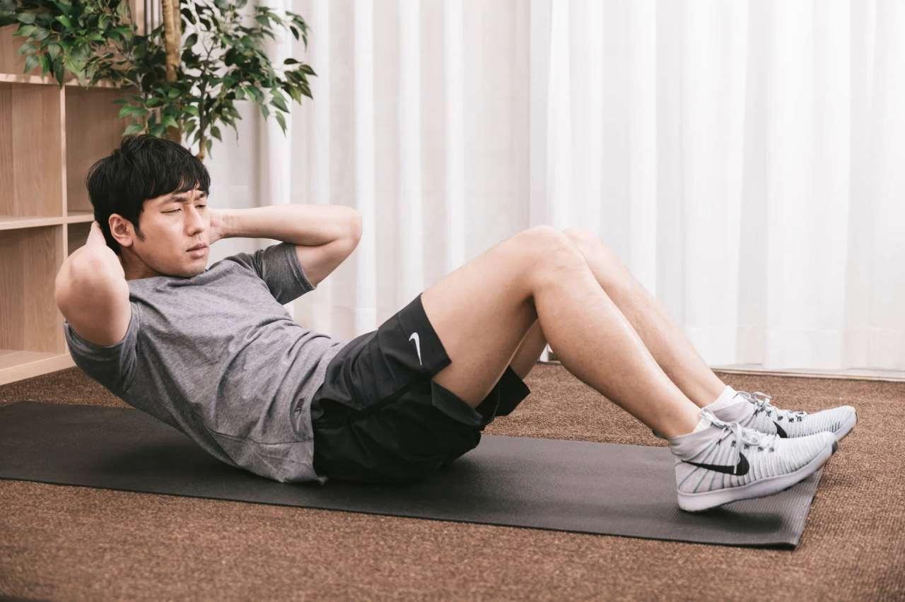 朝の室内でストレッチをするシニア男性