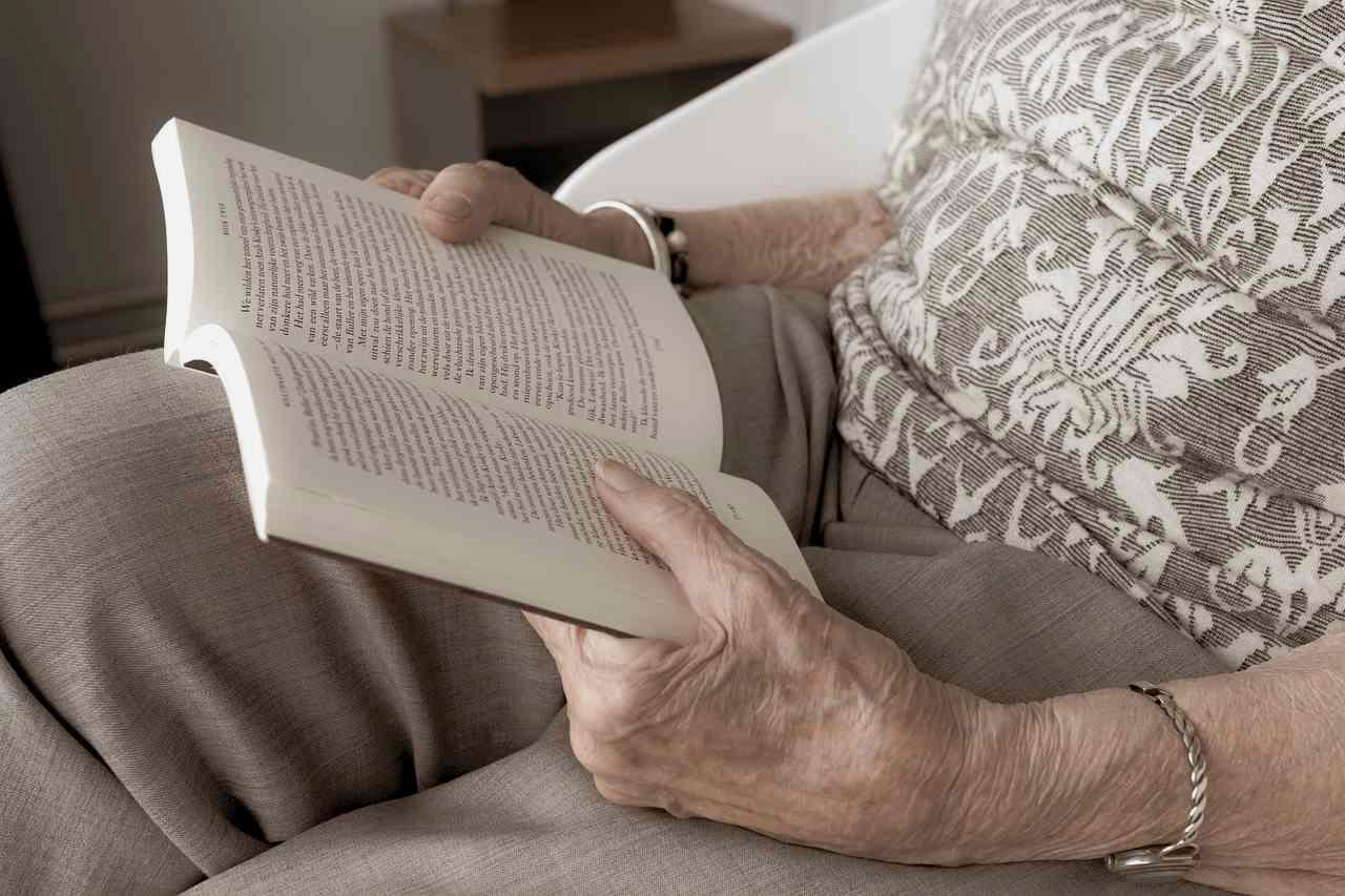 家計簿と電卓を前に、収支を書き出すシニア女性の手元