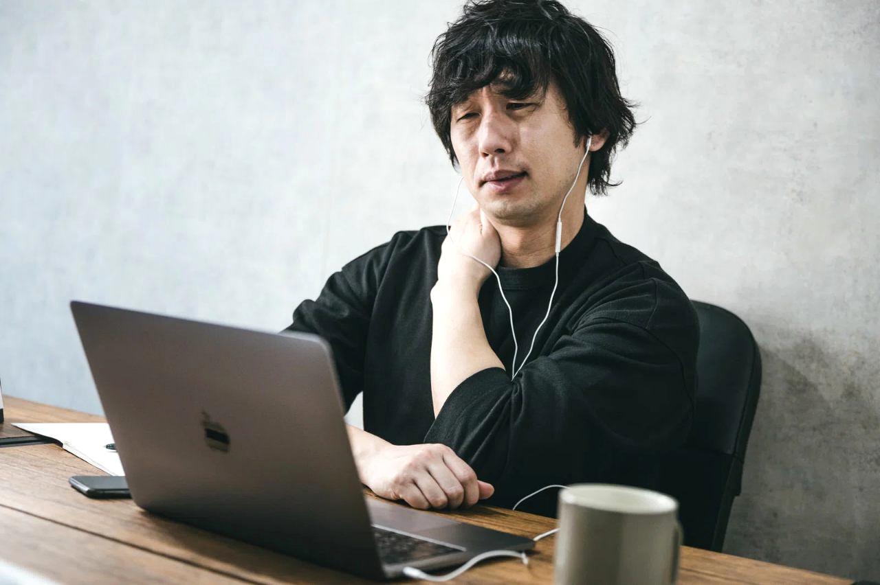 年間の保険証券や通信料金明細をテーブルに広げてチェックする中年男性