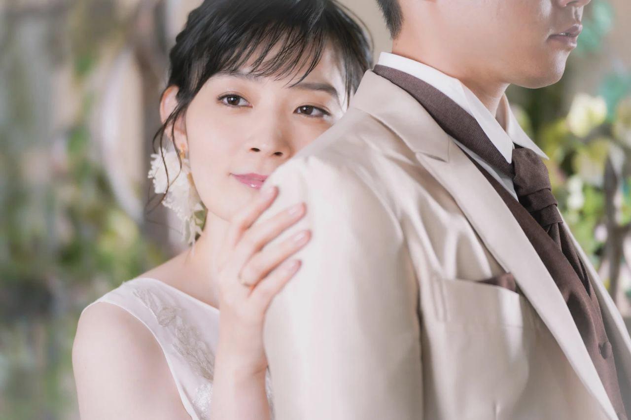 40代男性が窓辺に立ち、外の光を見ながら穏やかな表情で未来に思いを馳せる姿