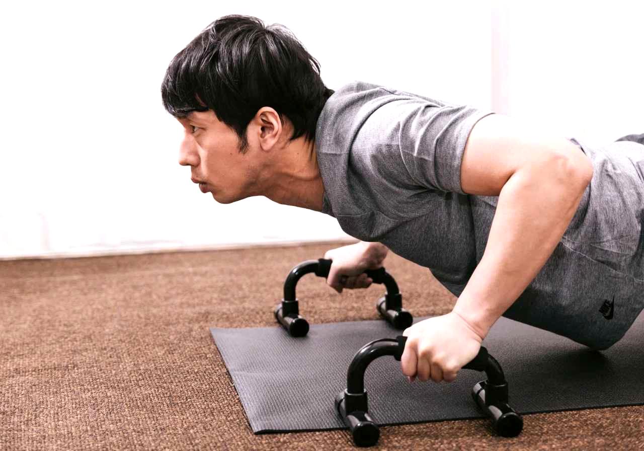体幹を意識してプランクの応用トレーニングを行う男性