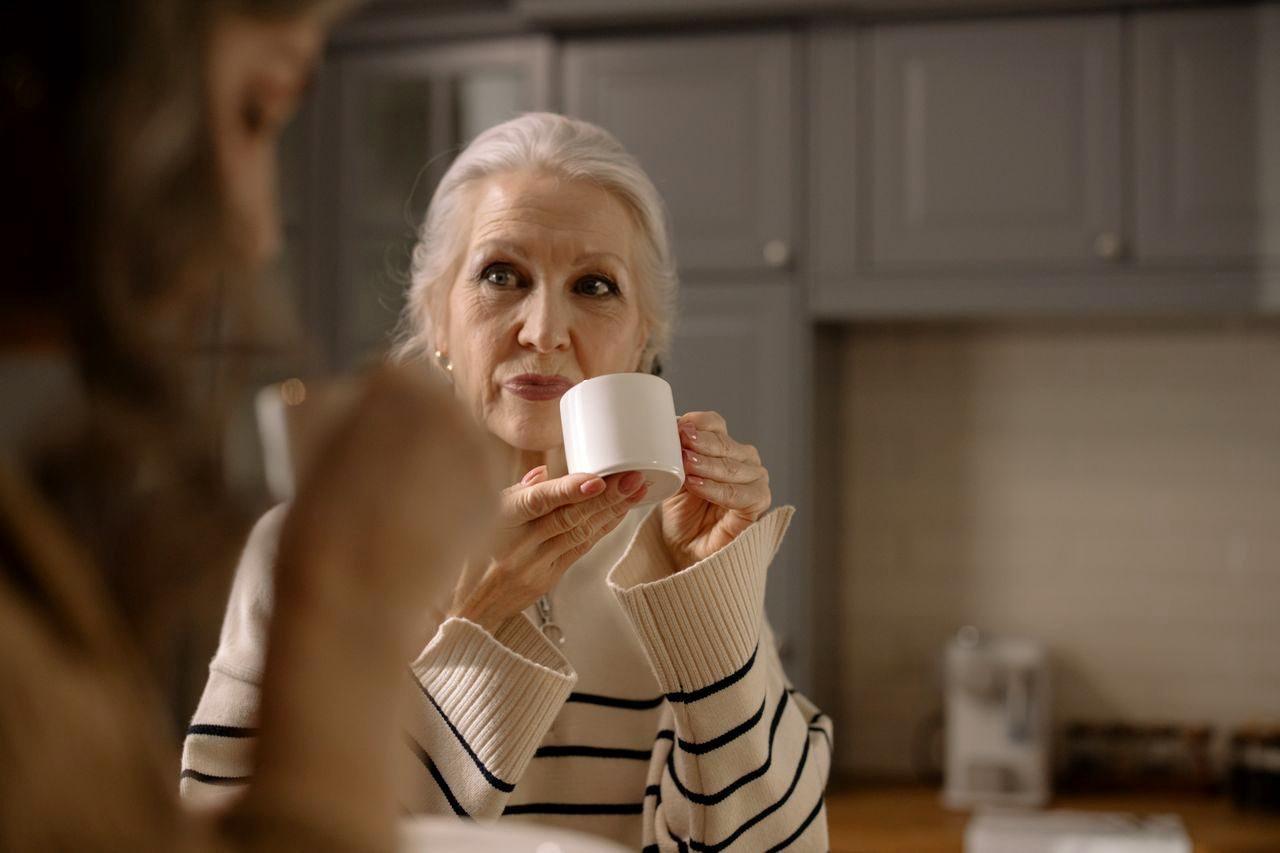 60代女性がティータイムに人工甘味料の缶コーヒーを手にしている様子