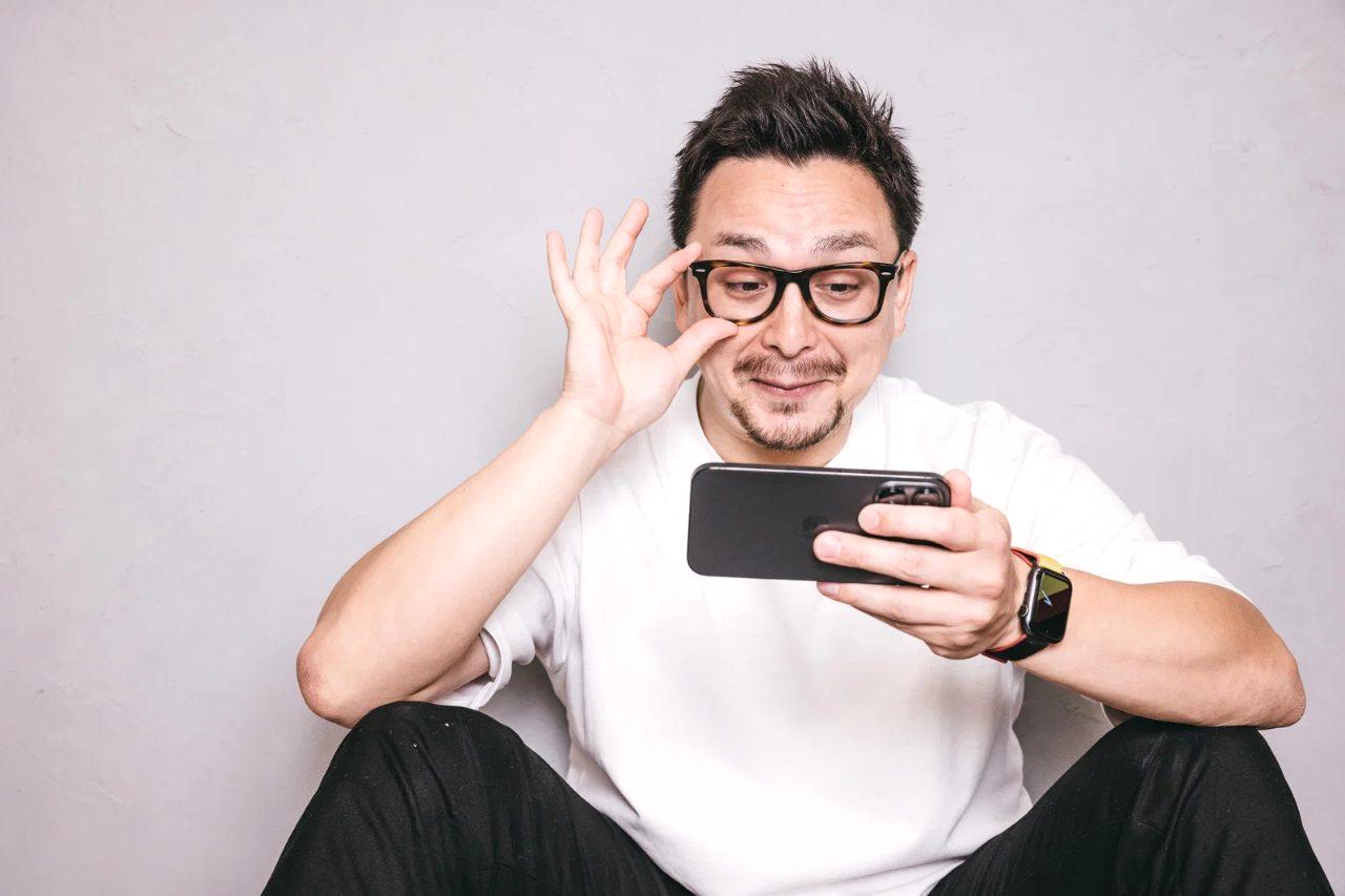 高齢者がスマホを使いビデオ通話で家族と話している楽しげな様子
